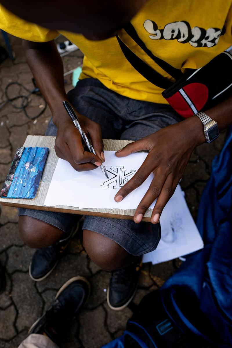 Hands sketching a design on paper, Nairobi